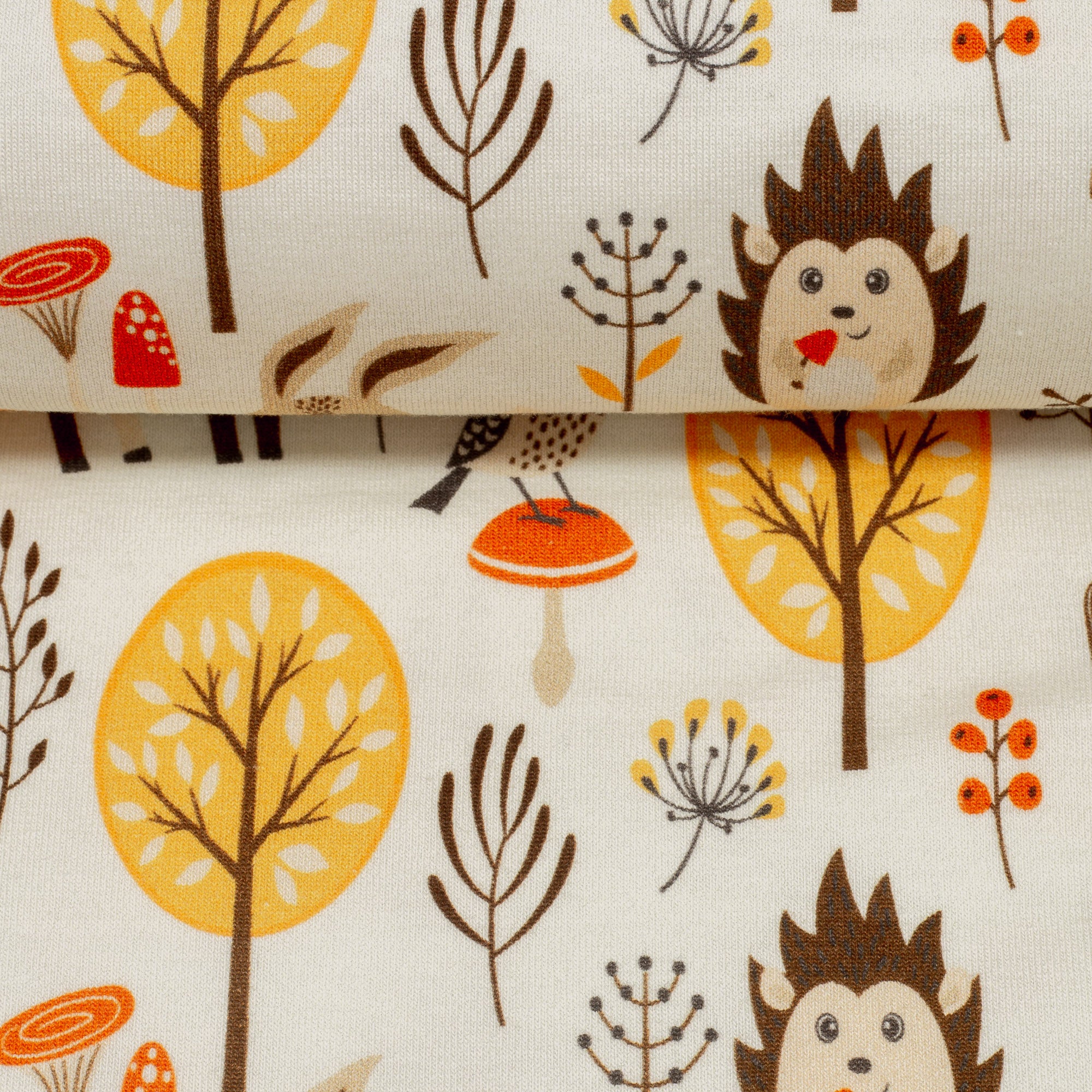 Zu sehen ist eine Nahaufnahme eines weichen, elastischen Baumwolljersey-Stoffs in cream mit Motiven von niedlichen Waldtieren wie Fuchs, Hase und Eule, der durch seine angenehme, glatte Oberfläche ideal für Kleidung, Accessoires und kreative DIY-Projekte geeignet ist.