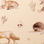 Zu sehen ist eine Nahaufnahme eines weichen, elastischen Baumwolljersey-Stoffs in beige mit Motiven von Waldtieren wie Reh, Fuchs und Hase, der durch seine angenehme, glatte Oberfläche ideal für Kleidung, Accessoires und kreative DIY-Projekte geeignet ist.
