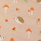 Zu sehen ist eine Nahaufnahme eines weichen, elastischen Baumwolljersey-Stoffs in hellrosa mit niedlichen Igeln in Naturfarben, der durch seine angenehme, glatte Oberfläche ideal für Kleidung, Accessoires und kreative DIY-Projekte geeignet ist.