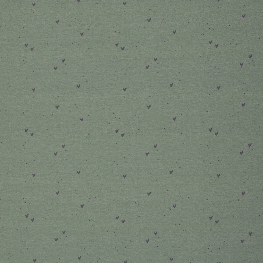 Zu sehen ist ein weicher, elastischer Baumwolljersey-Stoff in Grün mit süßen Herz-Motiven, der durch seine angenehme, glatte Oberfläche ideal für Kleidung, Accessoires und kreative DIY-Projekte geeignet ist.