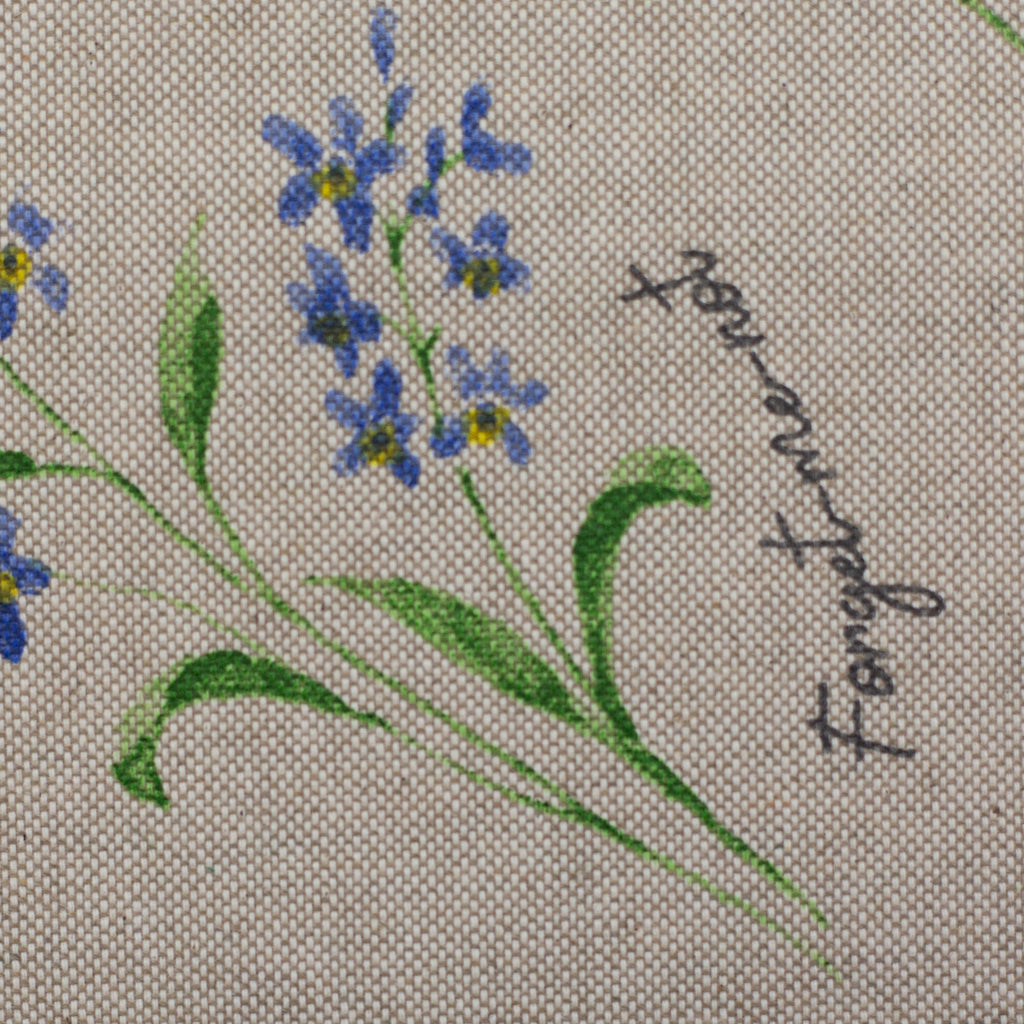 Zu sehen ist eine Nahaufnahme eines hochwertigen Deko-Baumwollstoffs in hellbraun mit schwarzer Schrift und einem detailreichen, farbenfrohen Blumenmuster, der durch seine angenehme Haptik und stabile Qualität ideal für kreative Näh- und Deko-Projekte geeignet ist.