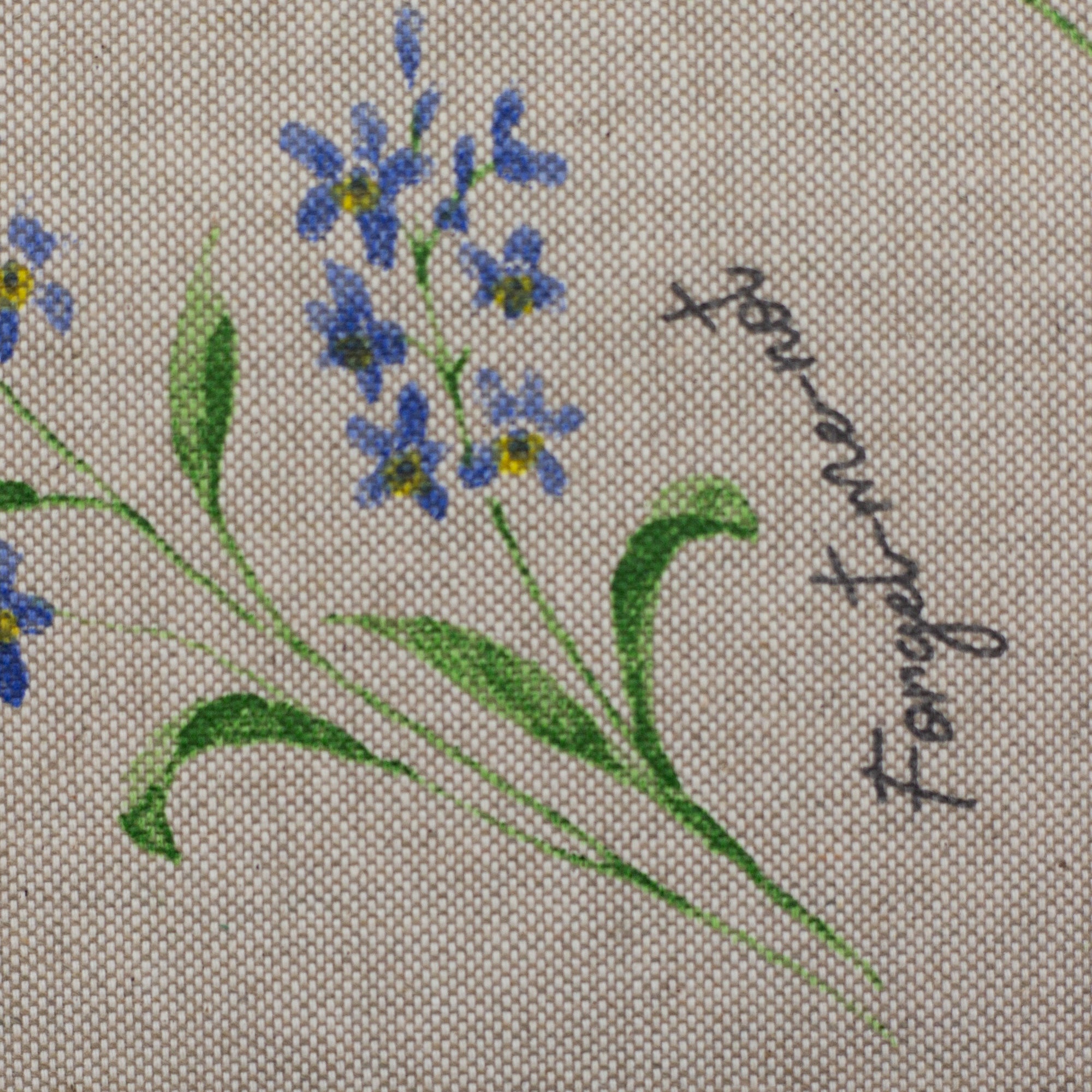 Zu sehen ist eine Nahaufnahme eines hochwertigen Deko-Baumwollstoffs in hellbraun mit schwarzer Schrift und einem detailreichen, farbenfrohen Blumenmuster, der durch seine angenehme Haptik und stabile Qualität ideal für kreative Näh- und Deko-Projekte geeignet ist.