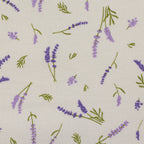 Zu sehen ist eine Nahaufnahme eines hochwertigen Deko-Baumwollstoffs in cream mit einem floralen Muster aus Lavendelblumen, der durch seine angenehme Haptik und stabile Webart ideal für kreative Näh- und Deko-Projekte geeignet ist.