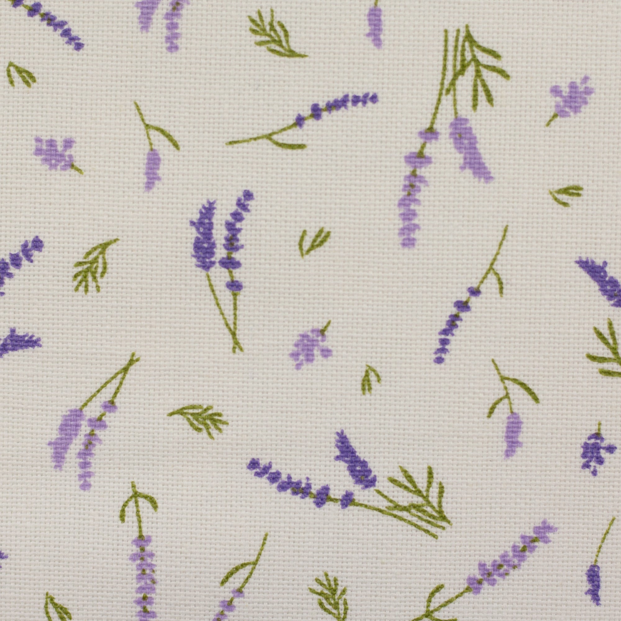Zu sehen ist eine Nahaufnahme eines hochwertigen Deko-Baumwollstoffs in cream mit einem floralen Muster aus Lavendelblumen, der durch seine angenehme Haptik und stabile Webart ideal für kreative Näh- und Deko-Projekte geeignet ist.