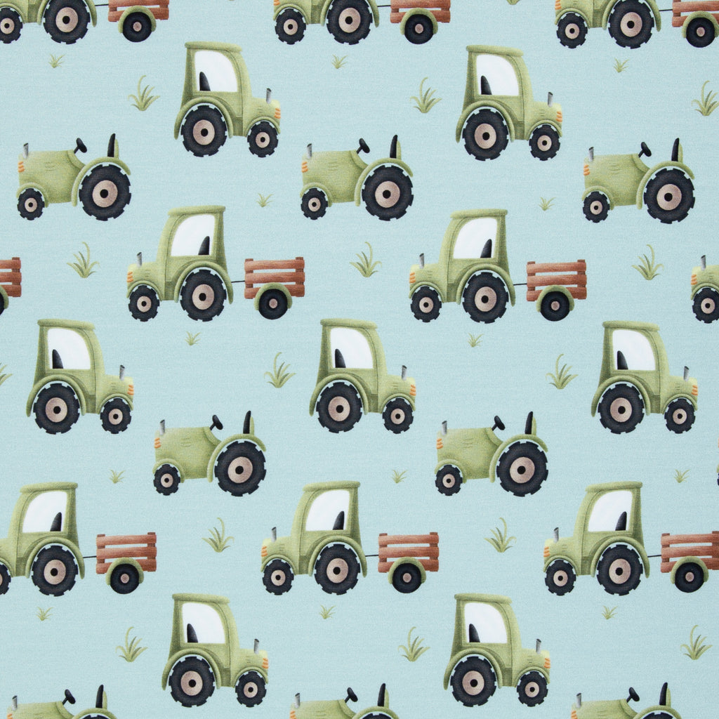 Zu sehen ist ein weicher, elastischer Baumwolljersey-Stoff in blau mit einem kindgerechten Muster aus Trucks, LKWs und weiteren Fahrzeugmotiven, der durch seine glatte und dehnbare Oberfläche ideal für Kleidung, Accessoires und kreative DIY-Projekte geeignet ist.