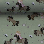 Zu sehen ist eine Nahaufnahme eines grünen Baumwolljerseys mit Pony- und Naturmotiven, elastisch, geeignet für Kinderkleidung und Accessoires.