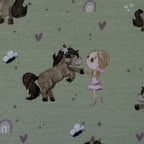 Zu sehen ist eine Nahaufnahme eines grünen Baumwolljerseys mit Pony- und Naturmotiven, elastisch, geeignet für Kinderkleidung und Accessoires.