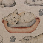 Nahaufnahme eines Canvas-Stoffs mit liebevollem Katzenmotiv, handgezeichneten Katzenillustrationen und warmen Natur-, Braun- und Beigetönen.