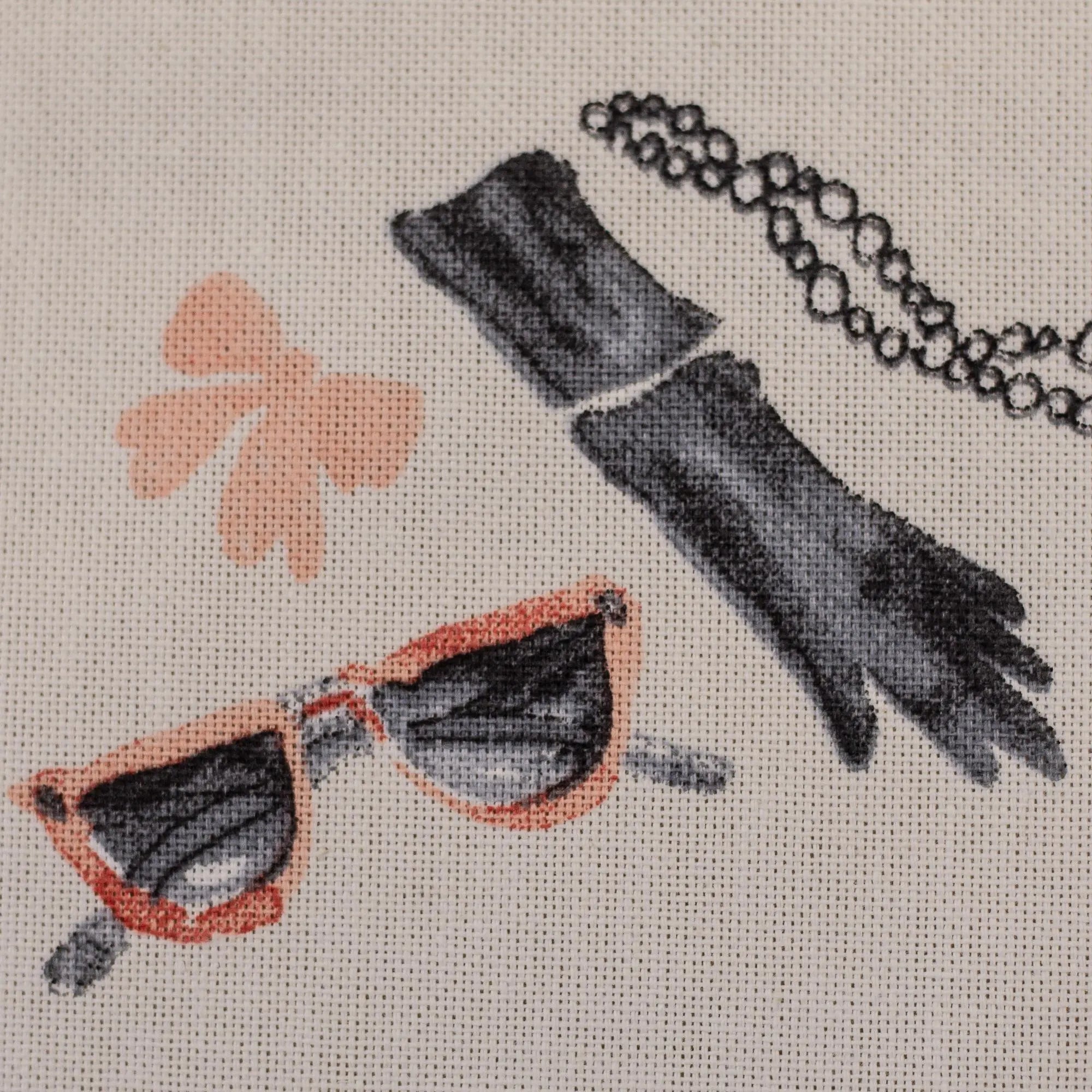 Nahaufnahme eines Canvas-Stoffs mit Paris-Fashion-Motiven, eleganten Damen, Eiffelturm, Parfum und Mode-Illustrationen.